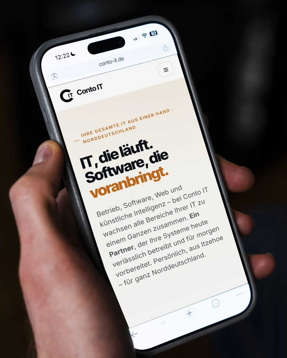 Smartphone in der Hand, darauf die Website von Conto IT